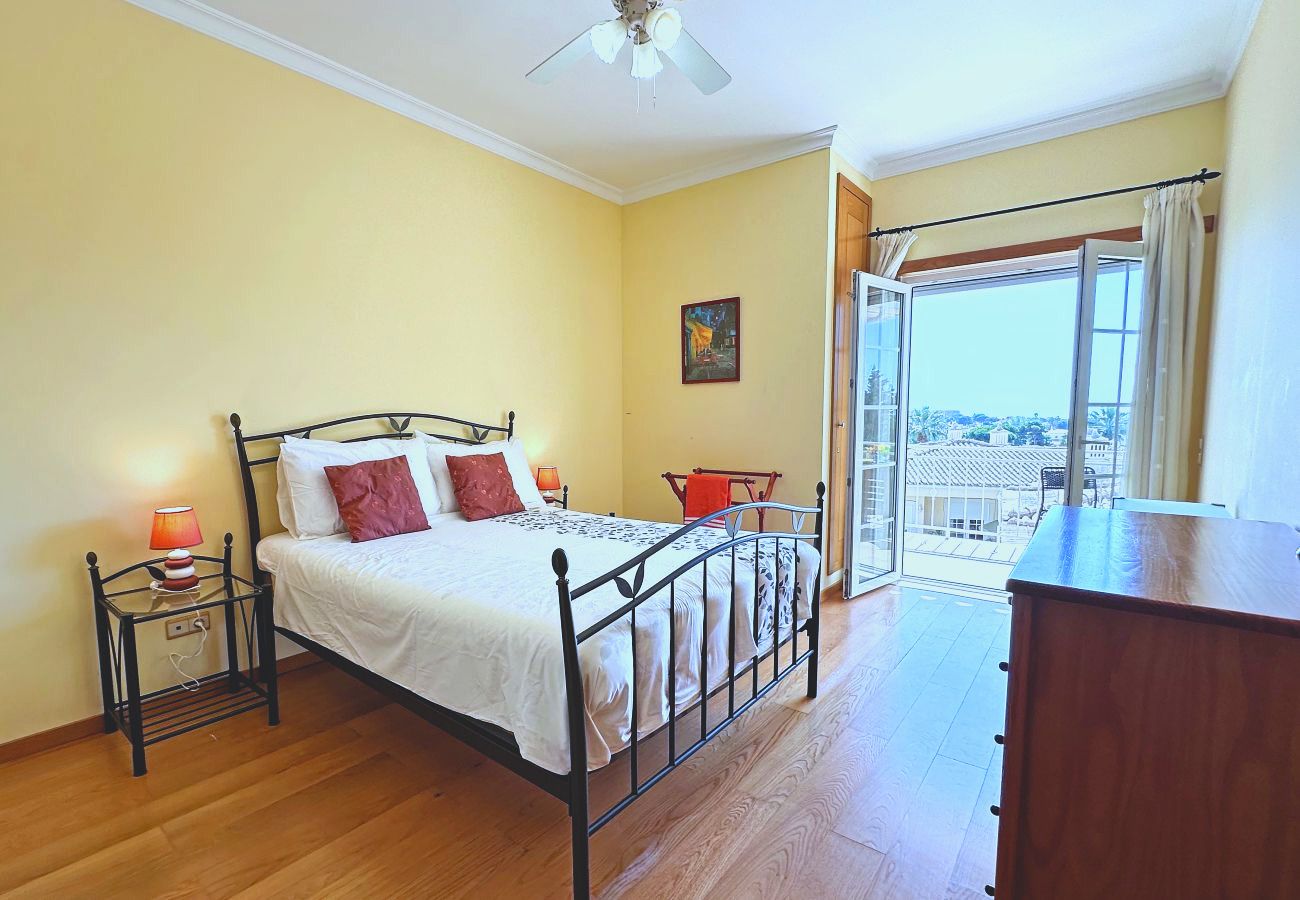 Das zweite Doppelzimmer mit einer hölzernen Kommode und einer Tür zum Balkon