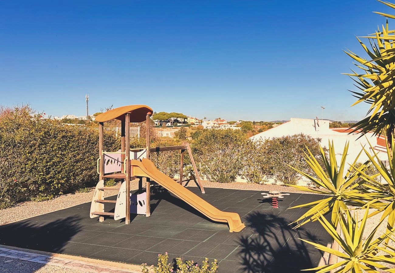 Der Spielplatz der Anlage mit einem hölzernen Klettergerüst und einer Rutsche auf weichem Untergrund