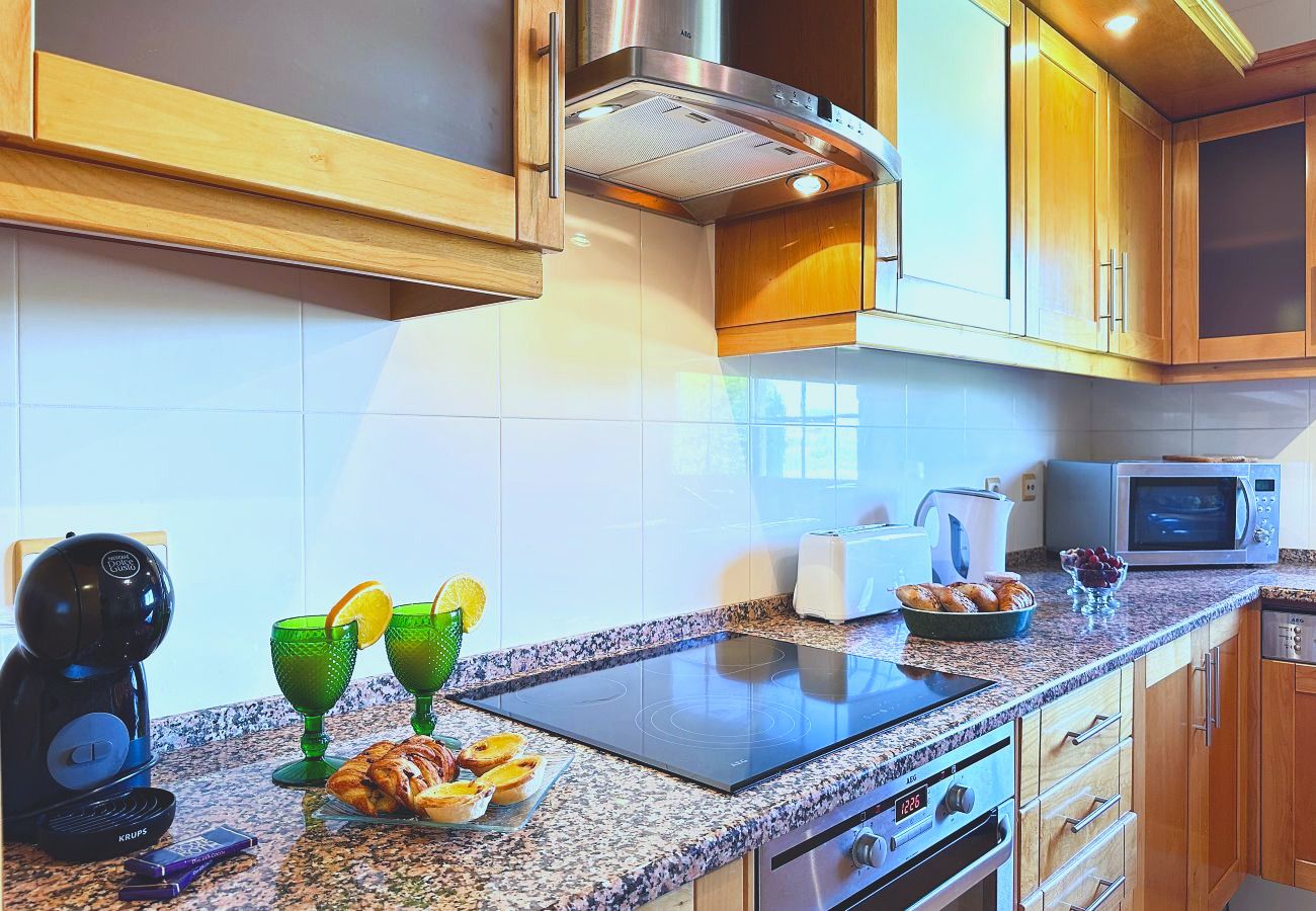 Küchendetail mit Induktionskochfeld, Granitarbeitsplatte, Mikrowelle und Kaffeemaschine