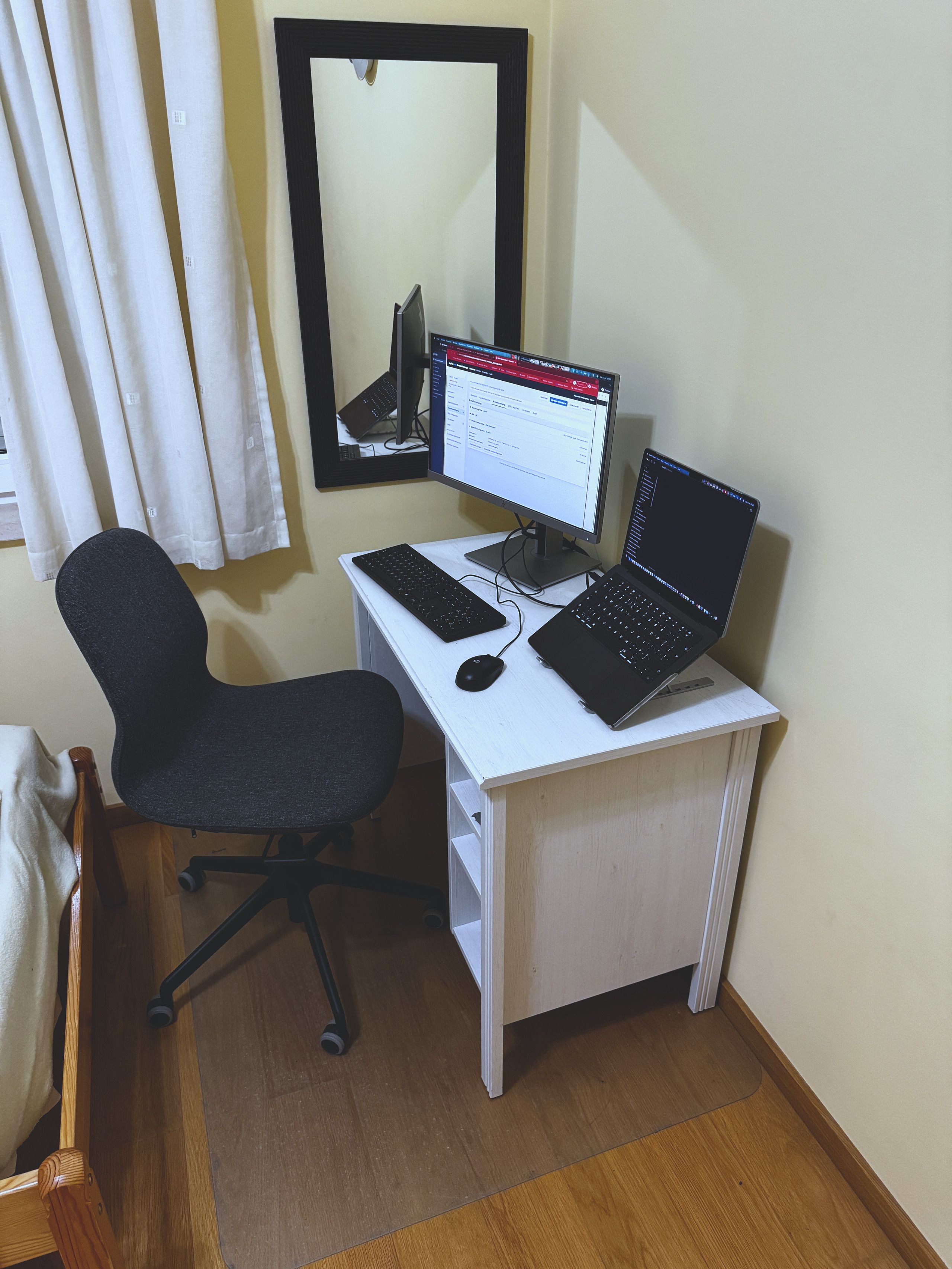 Der Schreibtisch im Zweibettzimmer, eingerichtet mit externem Monitor, Tastatur und Bürostuhl